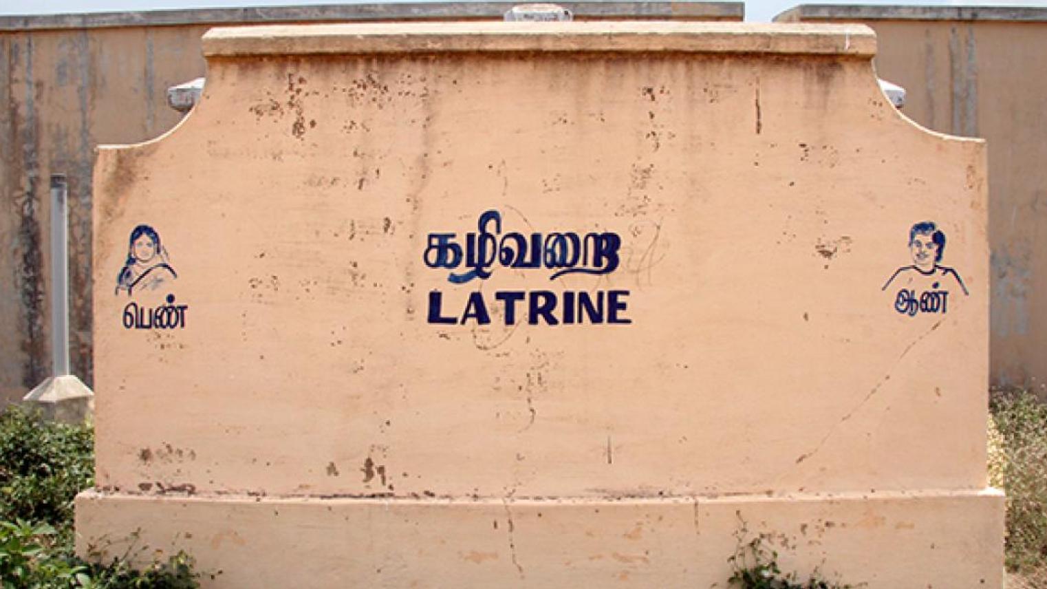 Outside wall of a concrete toilet building with Latrine written on the side